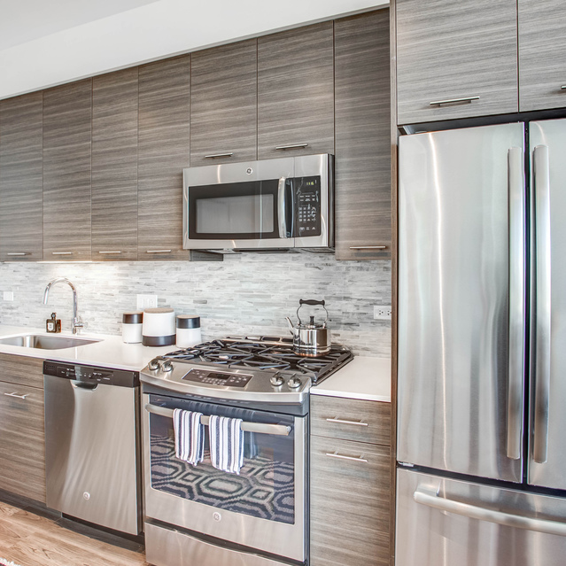 Next Apartments - Kitchen with Dishwasher, Refrigerator, and Microwave